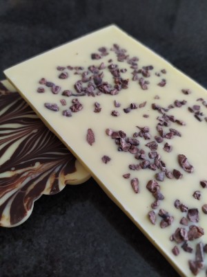 Bílá tabulka s kousky kakaových bobů